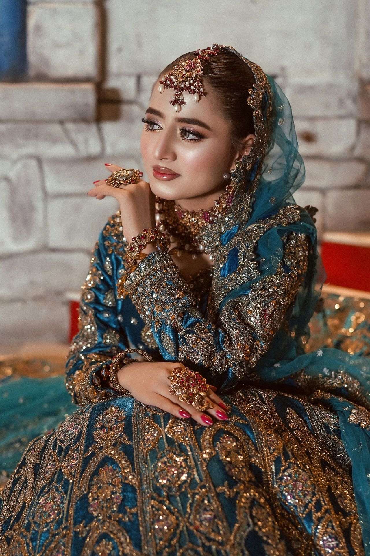 A beautiful bride poses in elaborate wedding attire.